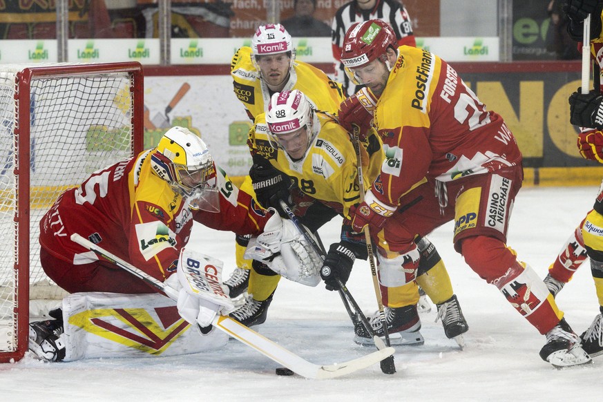 Biels Torhueter Harri Saeteri, links, und Beat Forster, rechts, im Duell mit Berns Benjamin Baumgartner im ersten Eishockey Playoff Viertelfinalspiel der National League zwischen dem EHC Biel und dem  ...