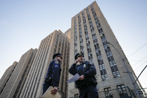 Police officers secure the perimeter outside Manhattan Criminal Court, Tuesday, April 4, 2023, in New York.  Former President Donald Trump wants to surrender in Manhattan on Tuesday to face criminal charges…