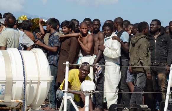 epa04902388 Some 250 migrants rescued in the Mediterranean Sea disembark from the Italian Coast Guard ship Fiorillo in the harbor of Reggio Calabria, southern Italy, 28 August 2015. The Italian Coast  ...