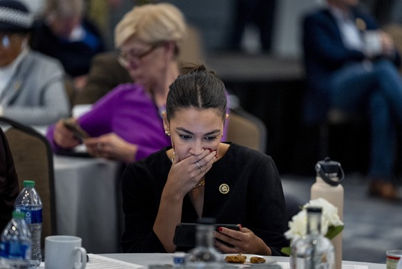 Rep. Alexandria Ocasio-Cortez, D-N.Y., reacts as she looks at a smartphone at the House Democratic Caucus Issues Conference at the Lansdowne Resort in Leesburg, Va., Thursday, Feb. 8, 2024. (AP Photo/Andr..