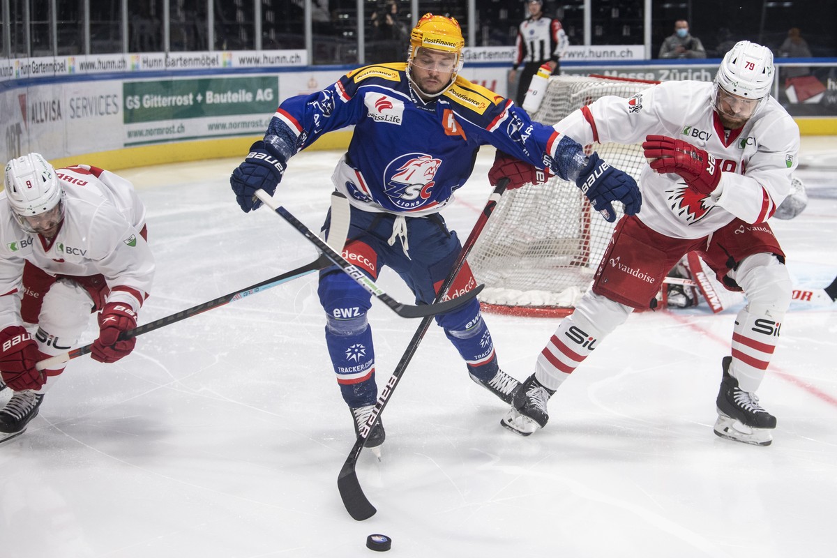 Lausannes Brian Gibbons, links, und Joel Genazzi, rechts, kaempfen um den Puck gegen Zuerichs Top Scorer PostFinance Sven Andrighetto, im Eishockeyspiel der National League zwischen den ZSC Lions und  ...