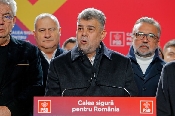 epa11738932 Prime minister Marcel Ciolacu (C), leader of the PSD (Social Democracy Party) party and presidential candidate delivers his speech at the PSD campaign headquarters after the first exit-pol ...