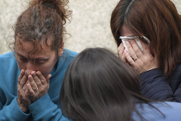 epa05867918 Family and friends mourn the death of four people in the parish of Sao Verissimo, municipality of Barcelos, northern Portugal, 24 March 2017. Portuguese police said they had taken a man in ...