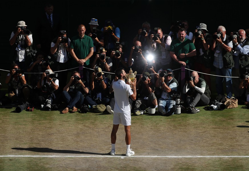 Novak Djokovic of Serbia kisses the trophy after defeating Kevin Anderson of South Africa in the men&#039;s singles final match at the Wimbledon Tennis Championships in London, Sunday July 15, 2018. ( ...