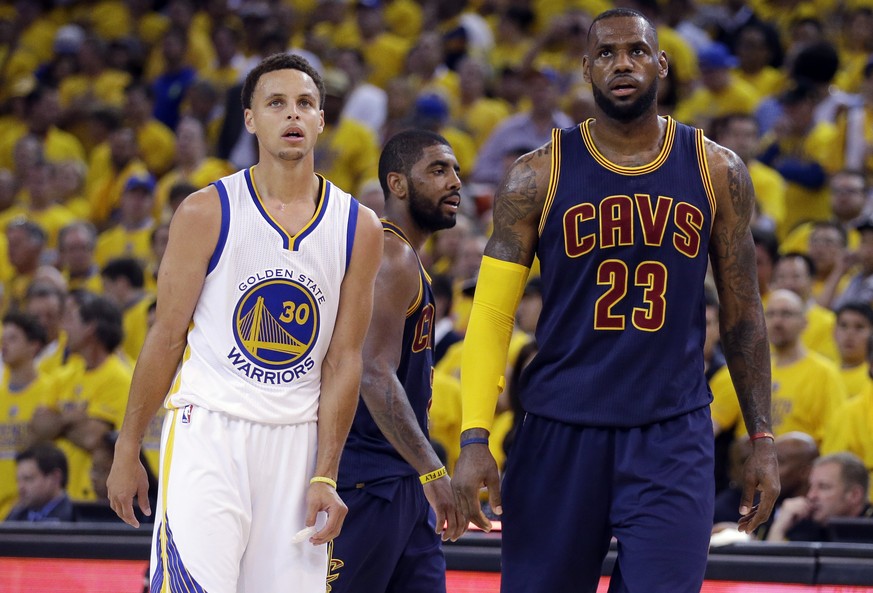 Golden State Warriors guard Stephen Curry (30) and Cleveland Cavaliers forward LeBron James (23) walk on the floor during the second half of Game 1 of basketball&#039;s NBA Finals in Oakland, Calif.,  ...