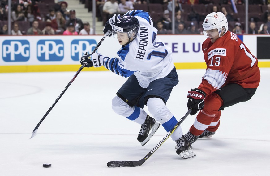 Finland&#039;s Aleksi Heponiemi (10) stick-handles past Switzerland&#039;s Justin Sigrist (13) during first-period IIHF world junior semifinal hockey action in Vancouver, British Columbia, Friday, Jan ...