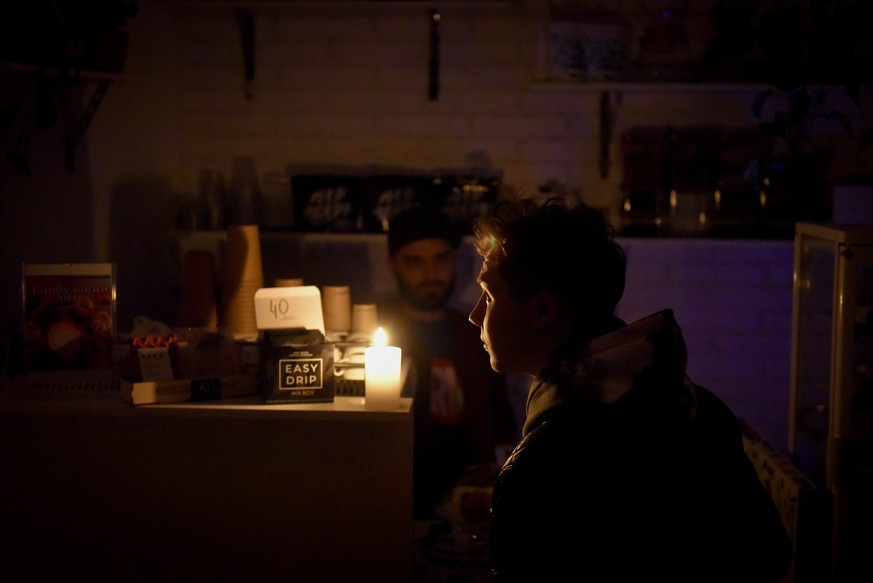 epa10269667 A barista speaks with a customer in a cafe during electricity shortage in Kyiv, Ukraine, 27 October 2022. Scheduled power cuts were introduced all over the country, including capital Kyiv, ...