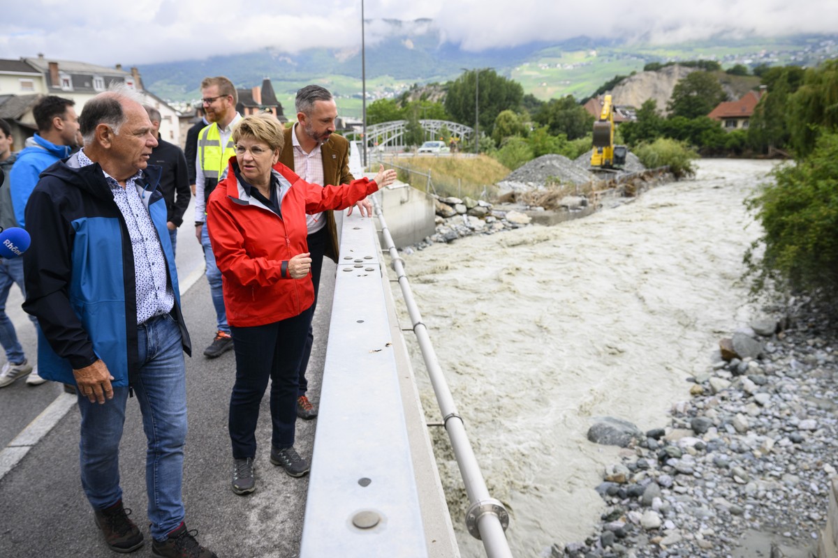 epa11449428 Swiss Federal President Viola Amherd (C), Frederic Favre, State Councillor of the Canton of Valais (R) and Chippis President Olivier Perruchoud (L) visit regions hit by bad weather, in Chi ...