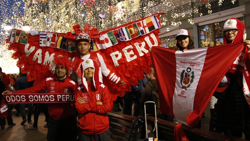 Fans of Peru stand to pose for pictures with passing fans from other countries, as visitors and Russians alike gathered to celebrate and cheer on their teams on the eve of the 2018 soccer World Cup, o ...