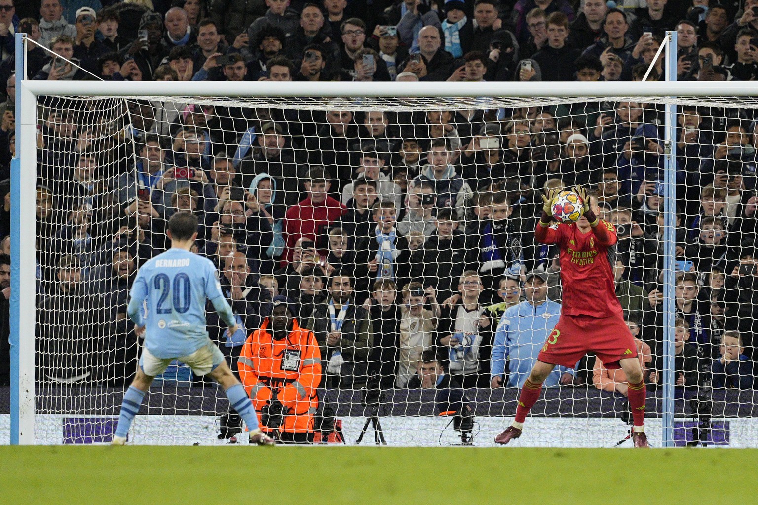 Real Madrid&#039;s goalkeeper Andriy Lunin, right, saves a penalty by Manchester City&#039;s Bernardo Silva during a shootout during the Champions League quarterfinal second leg soccer match between M ...