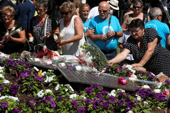 Angehörige der Opfer legen Blumen nieder.