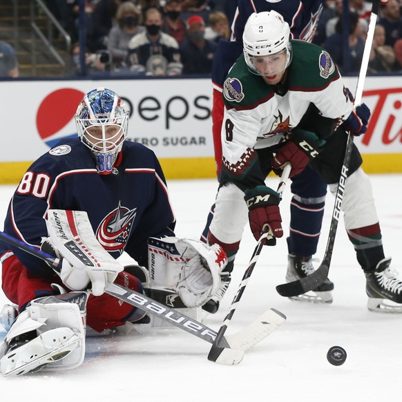 Columbus Blue Jackets' Elvis Merzlikins, left, makes a save against Arizona Coyotes' Nick Schmaltz during the first period of an NHL hockey game Thursday, Oct. 14, 2021, in Columbus, Ohio. (AP Photo/J ...