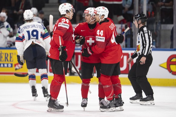 KEYPIX - Switzerland's Attilio Biasca, left, Switzerland's Theo Rochette, middle, and Switzerland's Pius Suter, right, celebrate after scoring the sixth goal during the 2026 IIHF Men  ...