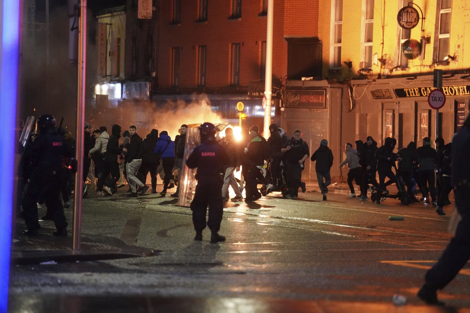 Irish police officers try to disperse a demonstration near the scene of an attack in Dublin city center, Thursday Nov. 23, 2023. A 5-year-old girl is receiving emergency medical treatment in a Dublin  ...