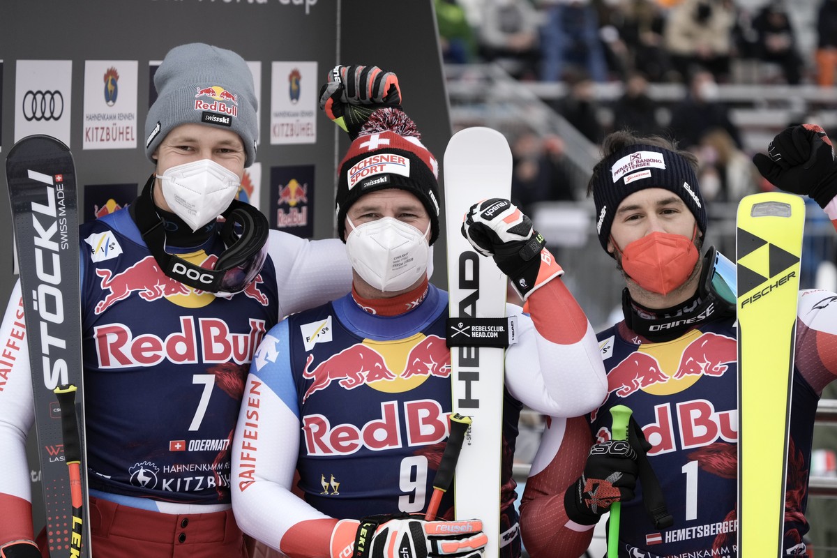 Switzerland's Beat Feuz, center, winner of an alpine ski, men's World Cup downhill, stands with second-placed Switzerland's Marco Odermatt, left, and third-placed Austria's Daniel  ...