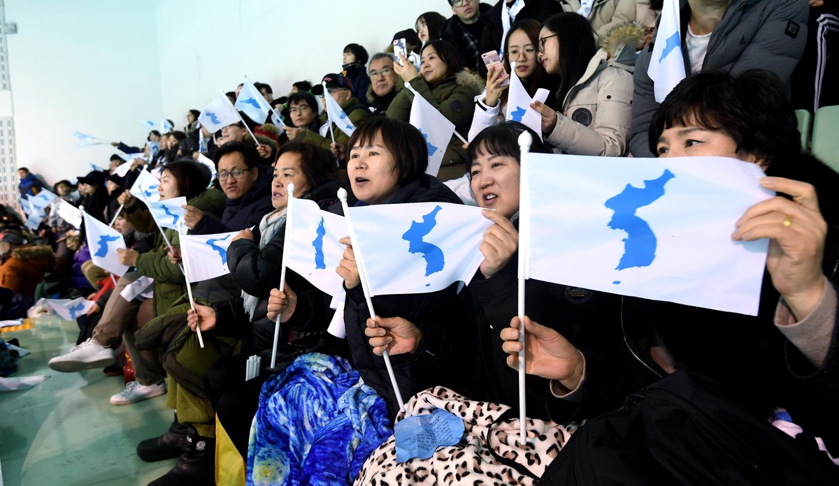 epa06497107 People wave the Korean Unification Flag, while the joint Korean women's hockey team faces Sweden for an exhibition game at Seonhak International Ice Rink in Incheon, South Korea, 04 F ...