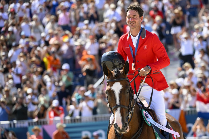 Silver medalist Steve Guerdat of Switzerland riding Dynamix De Belheme celebrates after the victory cermony of the equestrian individual finals at the 2024 Paris Summer Olympics in Paris, France, Tues ...