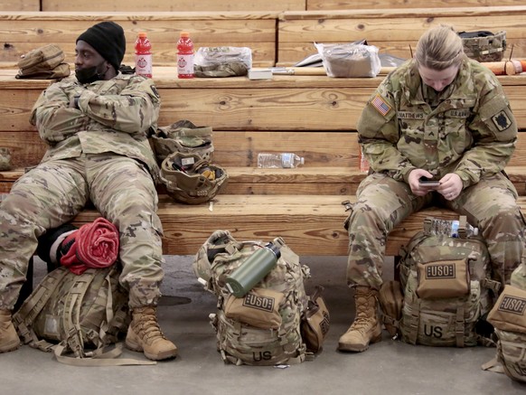 U.S. Army soldiers from the 18th Airborne Division sit in the staging area as they wait to board a C-17 aircraft to deploy to Europe on Thursday, Feb. 3, 2022 from Fort Bragg, N.C. President Joe Biden ...