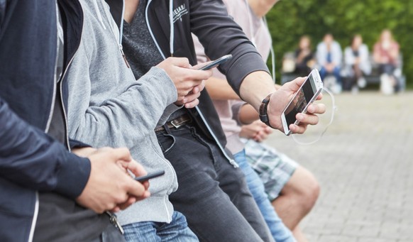 A group high school students use their smart phones on the schoolyard of their high school, photographed in Zug, Switzerland, on June 9, 2015. (KEYSTONE/Christof Schuerpf)

Eine Gruppe Gymnasiasten be ...