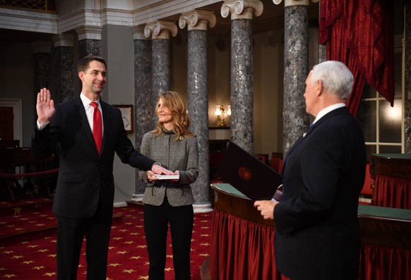 epa08917660 Sen. Tom Cotton, R-Ark., participates in a mock swearing-in for the 117th Congress with Vice President Mike Pence, as his wife Anna Peckham holds a bible, in the Old Senate Chambers at the ...