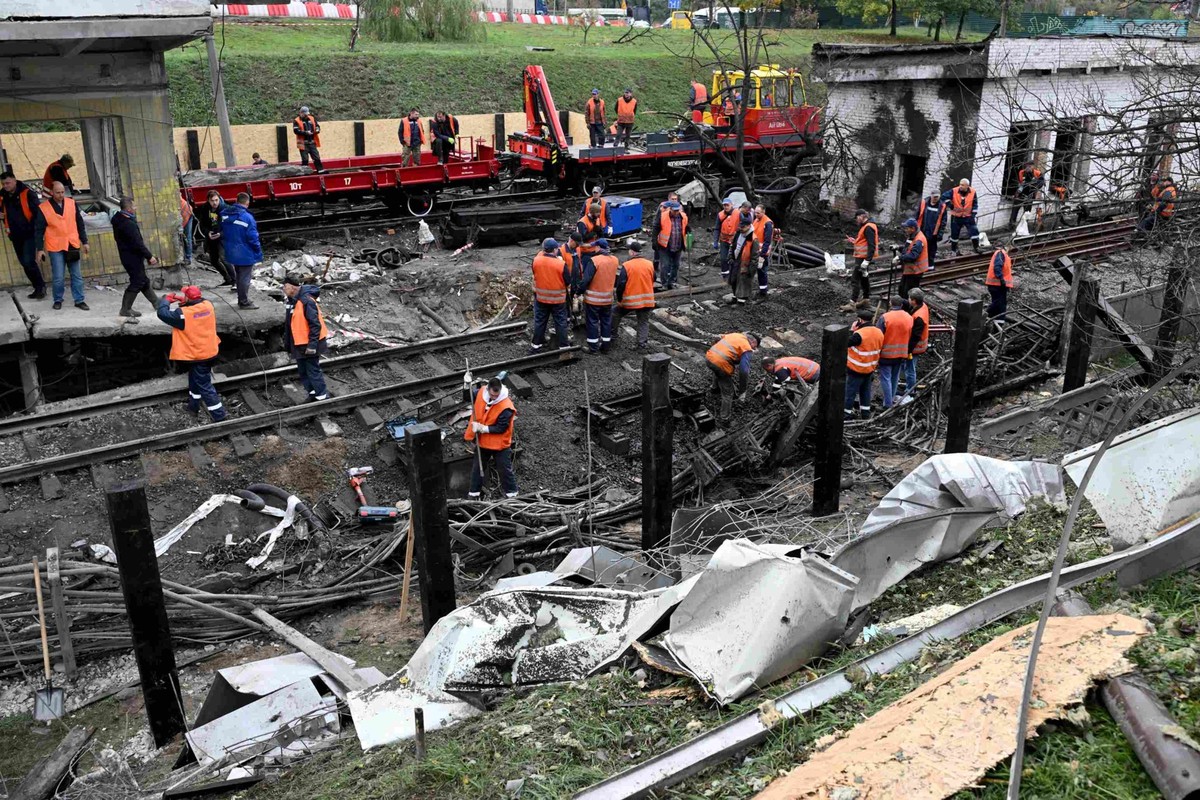 Des ouvriers déblayent les décombres d'une station de métro à la suite d'une frappe de missile balistique russe sur Kiev, le 19 octobre 2026.