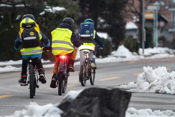 Schulkinder sind auf dem Weg in die Schule, am Freitag, 17. Dezember 2021, in Uetendorf. Aufgrund der hohen Corona Ansteckungen werden die Schulkinder im Kanton Bern eine Woche frueher in die Weihnach ...