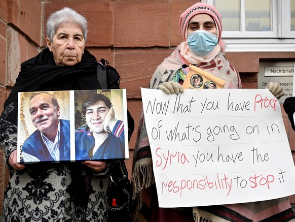 epa09682227 Women react after the verdict against a former Syrian secret police officer, at the Higher Regional Court in Koblenz, Germany, 13 January 2022. In the world&#039;s first trial on Syrian st ...