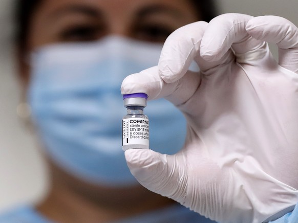 epa09492632 A Romanian nurse displays a vial of the vaccine against COVID-19 before a patient gets his booster injection, inside a jab boot organized at &#039;Matei Bals&#039; Covid-19 hospital in Buc ...