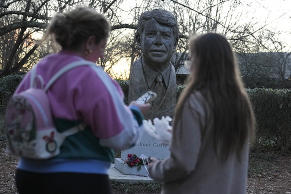 People visit a bust of former President Jimmy Carter at the Jimmy Carter Presidential Library and Museum on Sunday, Dec. 29, 2024, in Atlanta. (AP Photo/Brynn Anderson)