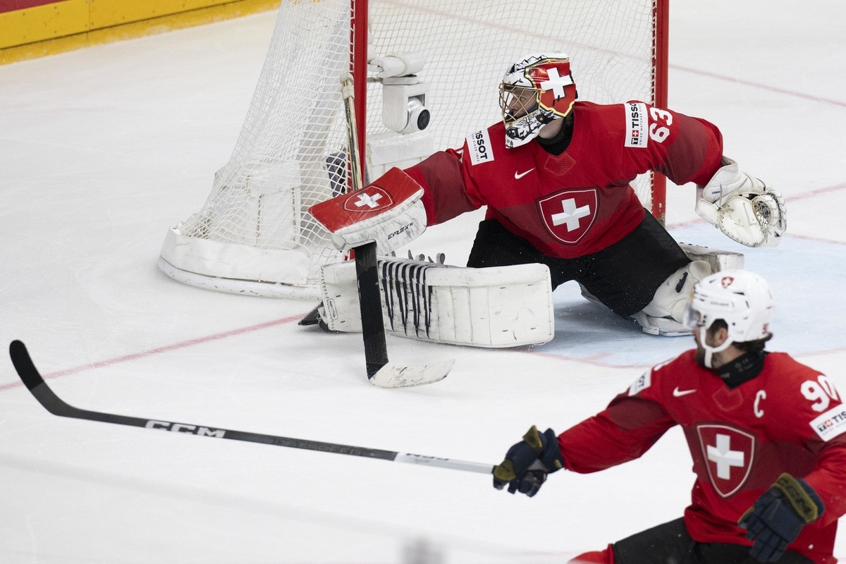 Switzerland's Goalkeeper Leonardo Genoni, left, and Switzerland's Roman Josi react after the first scoring to 1-0 during the Ice Hockey World Championship final match between Switzerland and ...