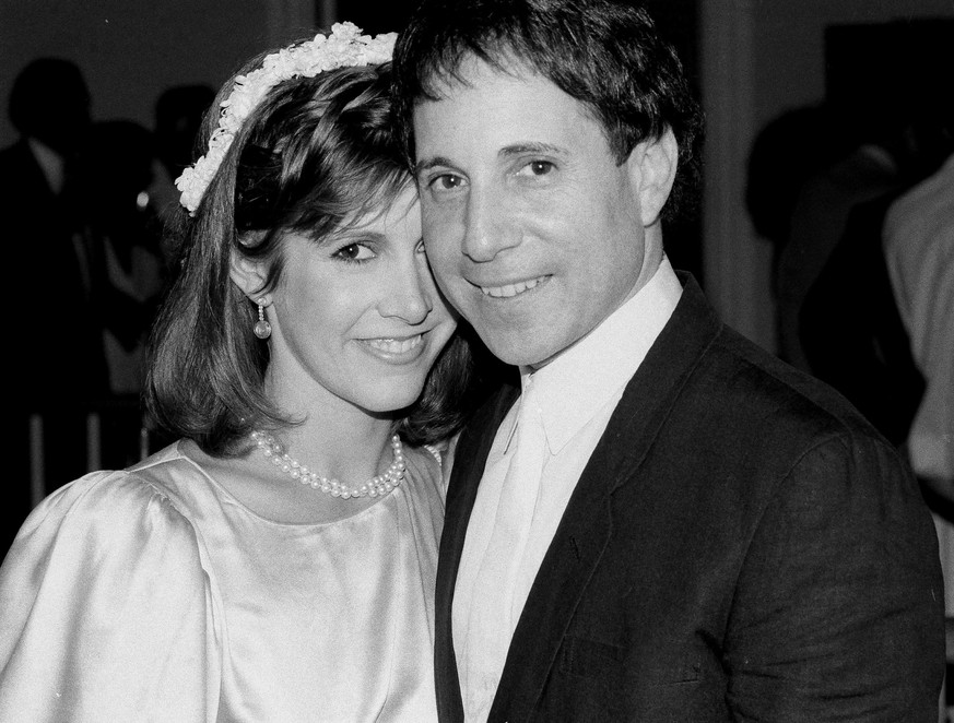 CORRECTS DATE AND SITUATION OF PHOTO TO 1983 WEDDING RECEPTION, NOT 1982 FUNERAL - FILE - In this Tuesday, Aug. 16, 1983 file photo, actress Carrie Fisher and singer Paul Simon stand together at their ...