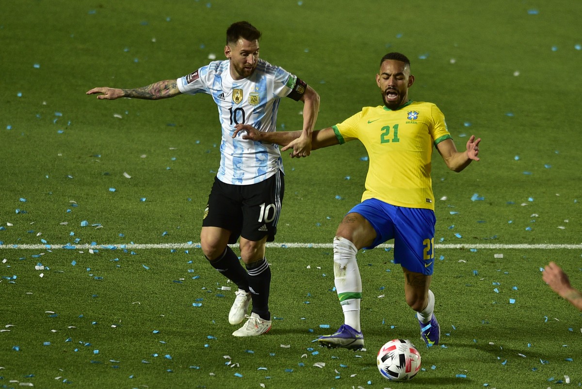 Brazil's Matheus Cunha, right, and Argentina's Lionel Messi battle for the ball during a qualifying soccer match for the FIFA World Cup Qatar 2022 at Bicentenario stadium in San Juan, Argent ...