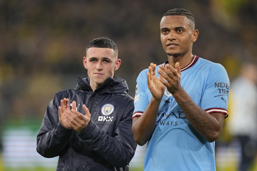 Manchester City's Phil Foden, left, and Manchester City's Manual Akanji applaud fans at the end of the Champions League Group G soccer match between Borussia Dortmund and Manchester City in Dortmund,  ...