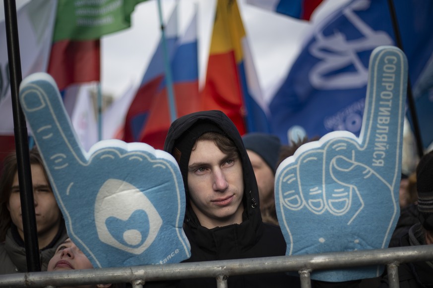 A man holds symbolic fingers with a word reading &quot;stand against&quot; during the Free Internet rally in response to a bill making its way through parliament calling for all internet traffic to be ...