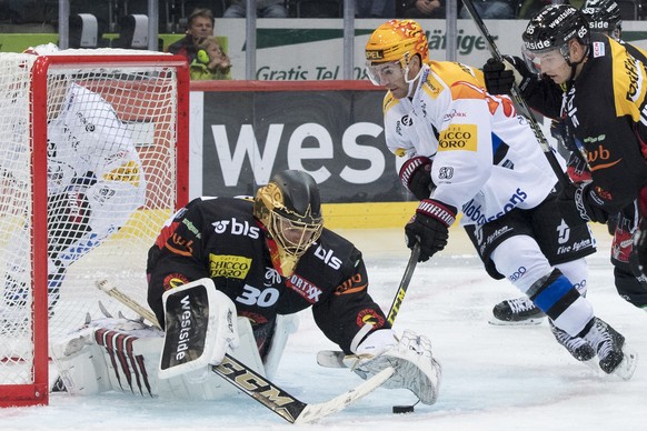 Bern Goalie Leonardo Genoni, links, und Fribourgs Top Scorer Jim Slater, rechts, kaempfen um den Puck, beim Eishockey Meisterschaftsspiel der National League zwischen den SC Bern und dem HC Fribourg G ...