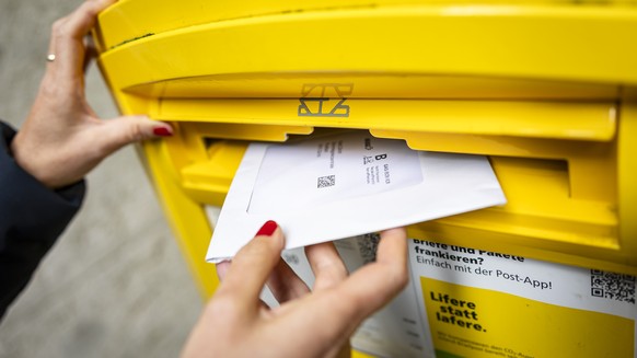 Eine Frau wirft ein Couvert mit Abstimmungsunterlagen fuer die Briefliche Stimmabgabge in einen Briefkasten der Post, am Dienstag, 17. September 2024 in Zuerich. .Die Schweizer Stimmbevoelkerung stimm ...