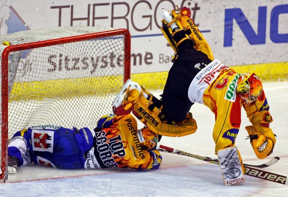 Der Davoser Peter Guggisberg, links, fliegt unter dem Langnauer Torhueter Matthias Schoder hindurch in dessen Tor beim Eishockey Meisterschaftsspiel der National League A zwischen dem HC Davos und den ...