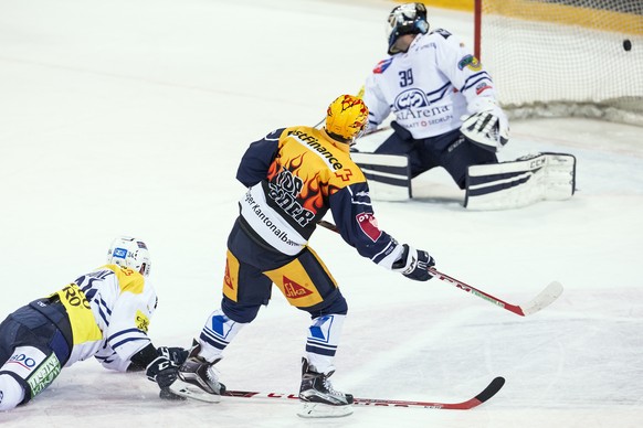 Zugs Lino Martschini, Mitte, trifft zum 1-0 gegen Ambris Adrian Trunz, links, und Ambris Torhueter Sandro Zurkirchen, rechts, im Eishockey Meisterschaftsspiel der National League A zwischen dem EV ZUG ...