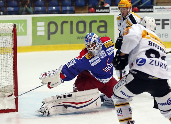 EHC Kloten Torhueter Luca Boltshauser, links, rettet gegen HC Lugano Stuermer Damien Brunner, vorne, und Tony Martensson waehrend dem Eishockey-Meisterschaftsspiel der National League A zwischen dem E ...