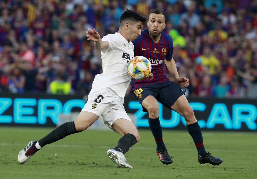 Valencia midfielder Carlos Soler, left, and Barcelona defender Jordi Alba battle for the ball during the Copa del Rey soccer match final between Valencia CF and FC Barcelona at the Benito Villamarin s ...