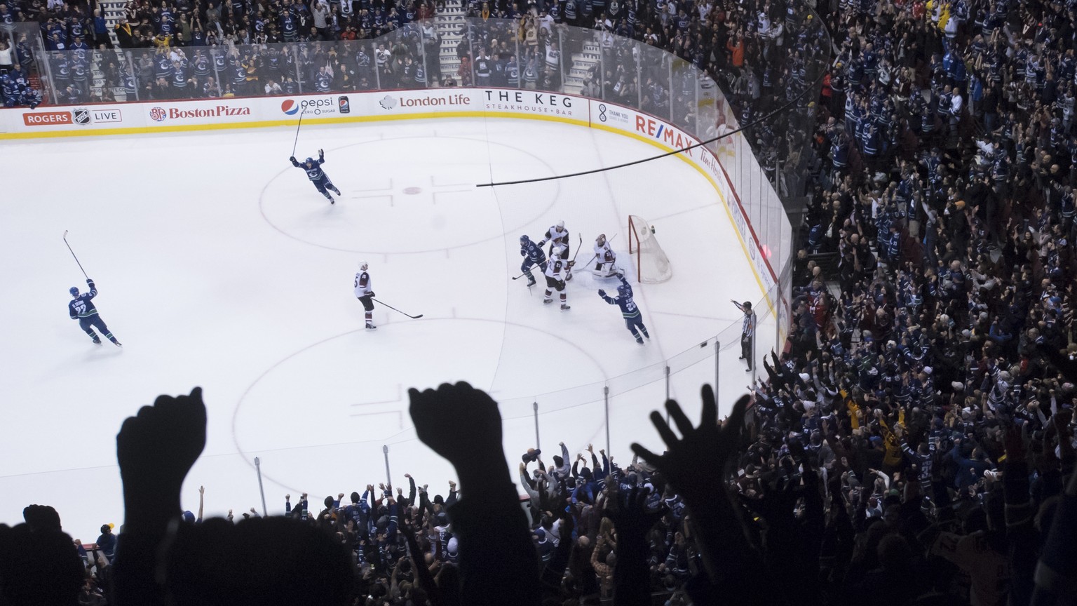 Vancouver Canucks left wing Daniel Sedin, left, celebrates his overtime goal against the Arizona Coyotes in an NHL hockey game Thursday, April 5, 2018, in Vancouver, British Columbia. (Jonathan Haywar ...