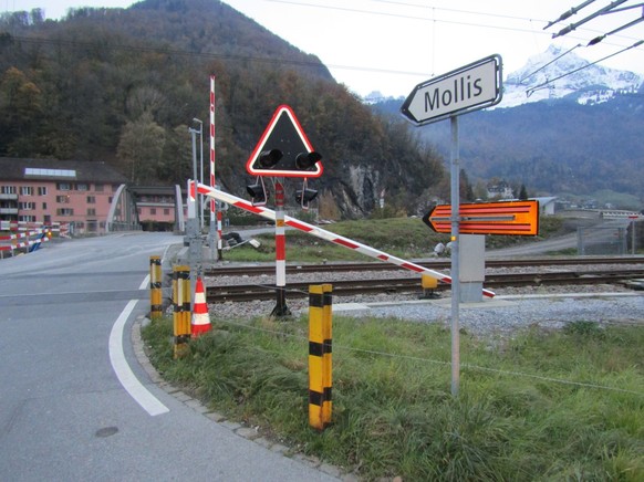 Sattelschlepper beschädigt in Näfels Bahnschranke und Auto