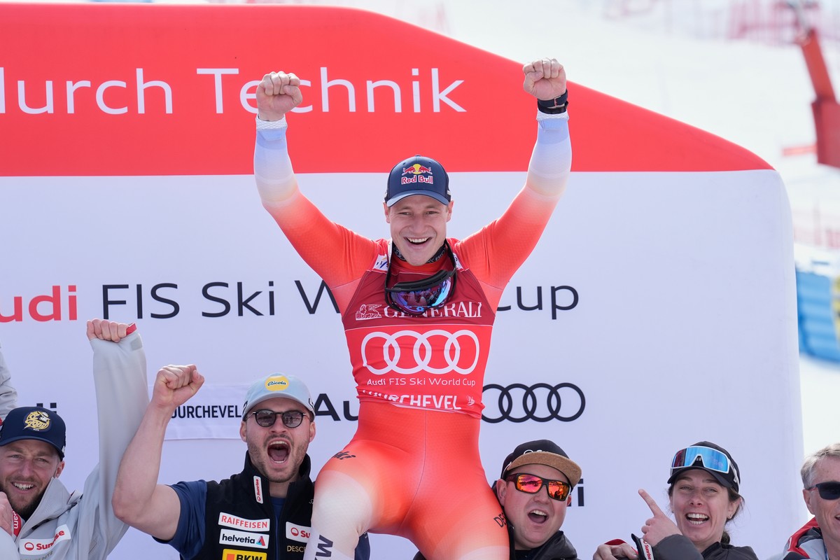 Switzerland's Marco Odermatt celebrates with the team after taking third place in an alpine ski, men's World Cup downhill race, in Courchevel, France, Friday, March 13, 2026. (AP Photo/Giova ...