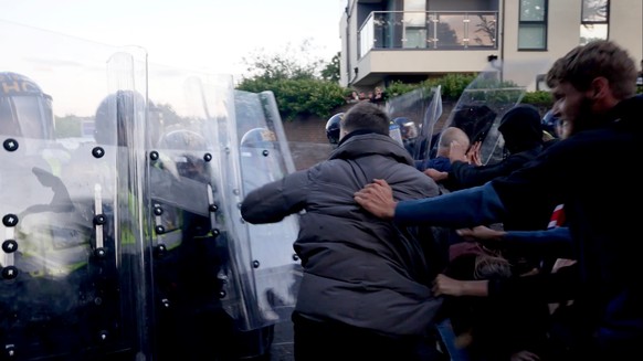 In this image taken from PA Video, police and protestors clash during a protest following the death of Henry Nowak, a 18-year-old student stabbed to death with a Sikh kirpan ceremonial by Vickrum Digw ...