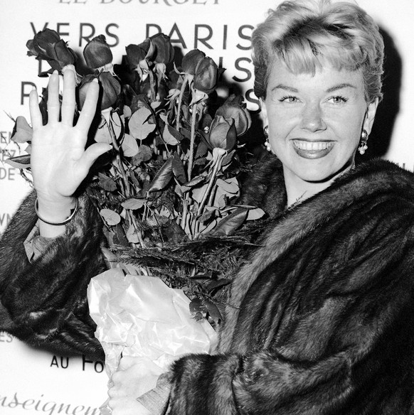 FILE - In this April 15, 1955 file photo, American actress and singer Doris Day holds a bouquet of roses at Le Bourget Airport in Paris, France after flying in from London. Day, whose wholesome screen ...