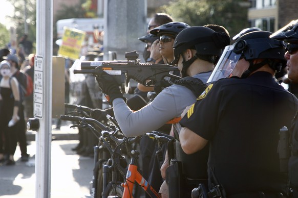 Police aim their weapons as protesters demonstrate against police brutality Saturday, May 30, 2020 in Tampa, Fla. Protests were held throughout the country over the death of George Floyd, a black man  ...