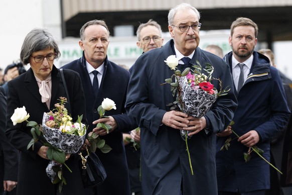 epa12812056 Swiss President Guy Parmelin (2-R) and his wife Caroline (L) with Romain Collaud (R), and Philippe Demierre (2-L), President of the Fribourg Council of State, lay flowers at the site where ...
