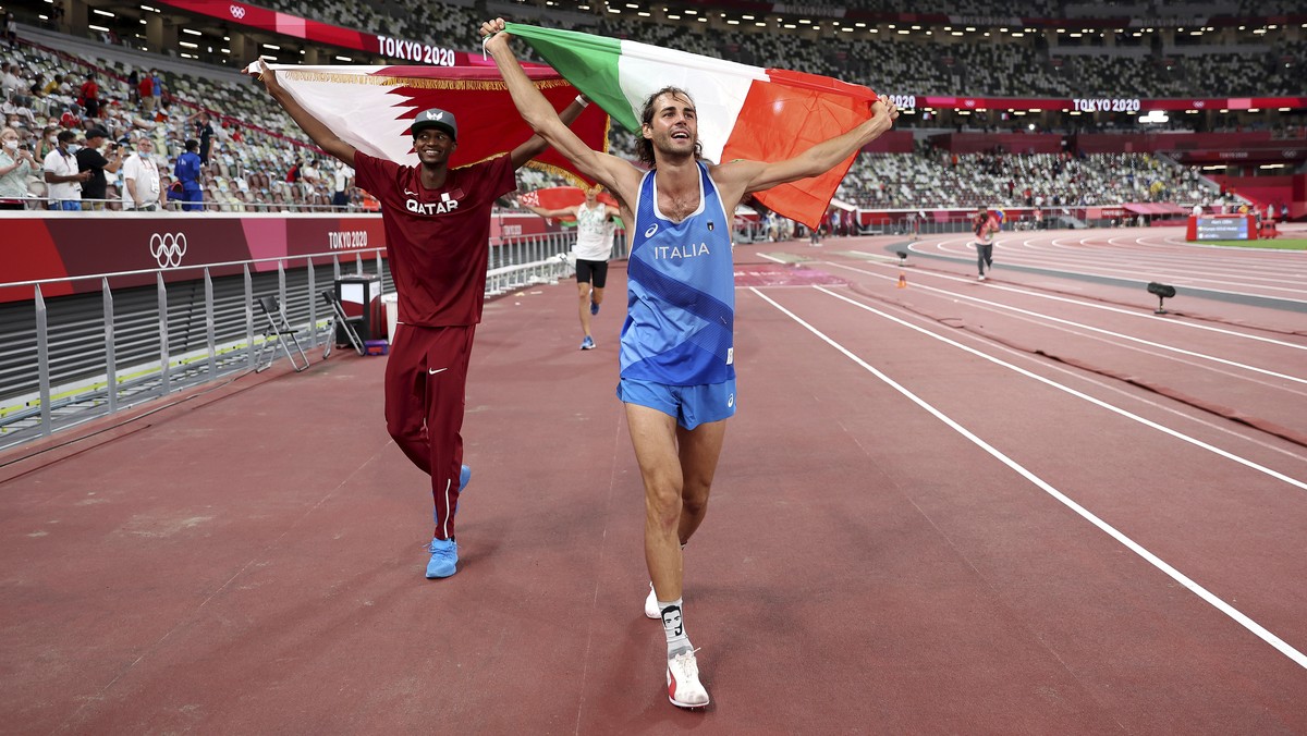 Gold medalist Mutaz Barshim, left, of Qatar and silver medalist Gianmarco Tamberi of Italy celebrate on the track after the final of the men's high jump at the 2020 Summer Olympics, Sunday, Aug.  ...