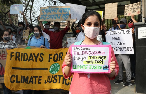 epa09083841 Climate activists and students hold banners and placards as they rally against climate change in New Delhi, India, 19 March 2021. Dozens of youth activists participated in a rally as part  ...
