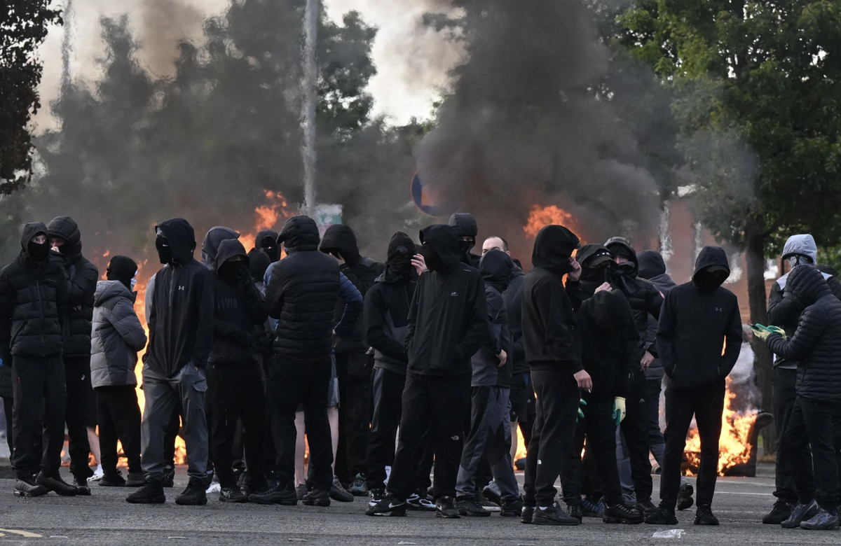 Des individus masqués participent à des émeutes à Belfast.